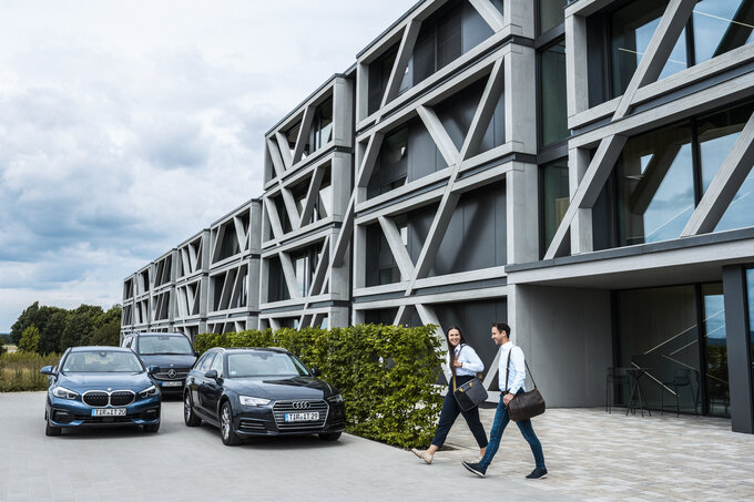 mitarbeitende verlassen das gebaeude richtung parkplatz