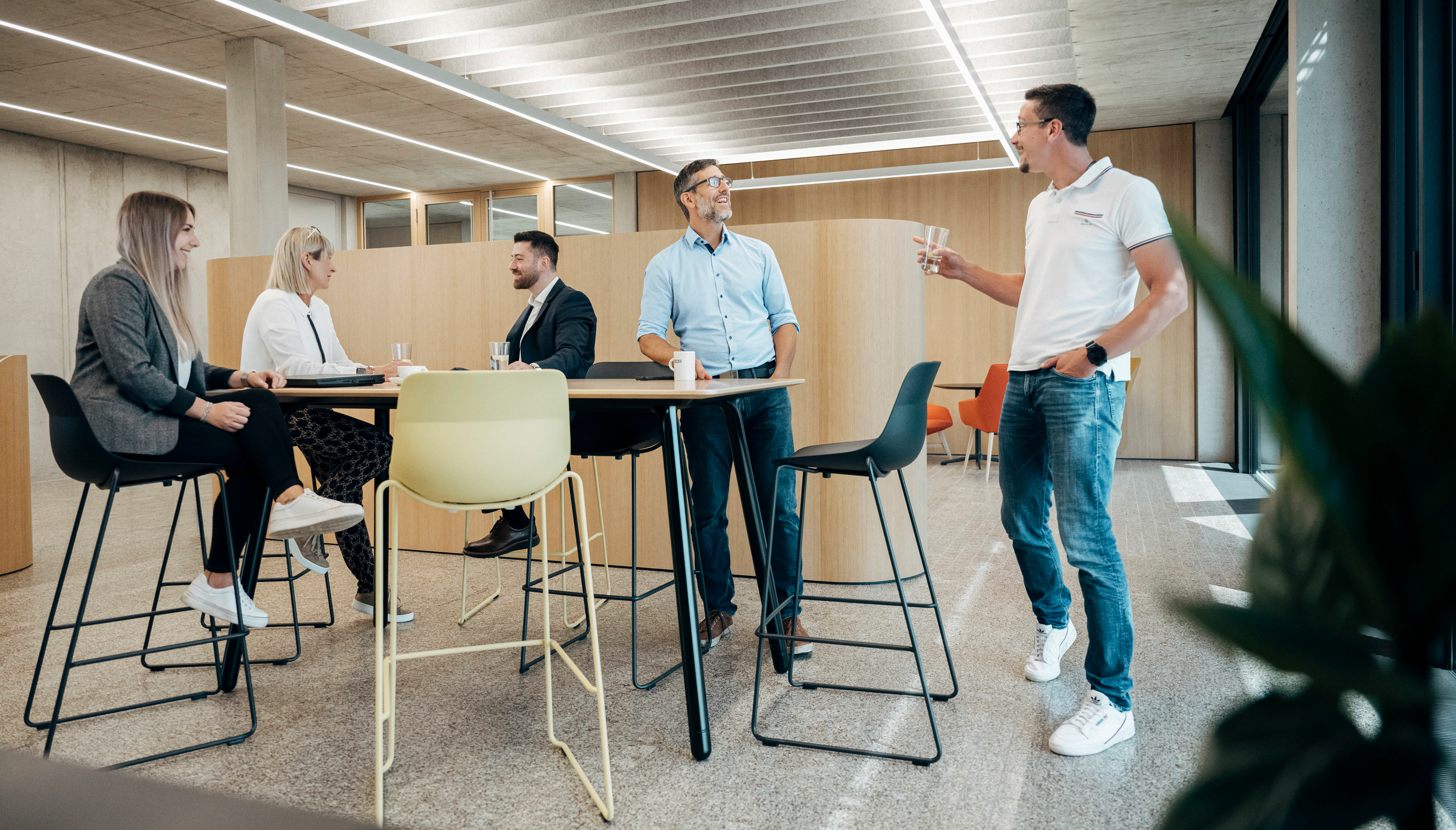 mitarbeitende sitzen im meeting point und unterhalten sich 