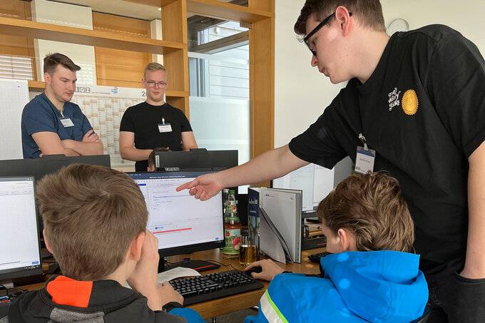 Betreuer erklärt Schüler*innen etwas am PC | FirstSteps@IGZ: Ausbildung in der IT | IGZ