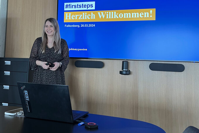 Betreuerin steht vor Leinwand und präsentiert grinsend einen Vortrag | FirstSteps@IGZ: Ausbildung in der IT | IGZ