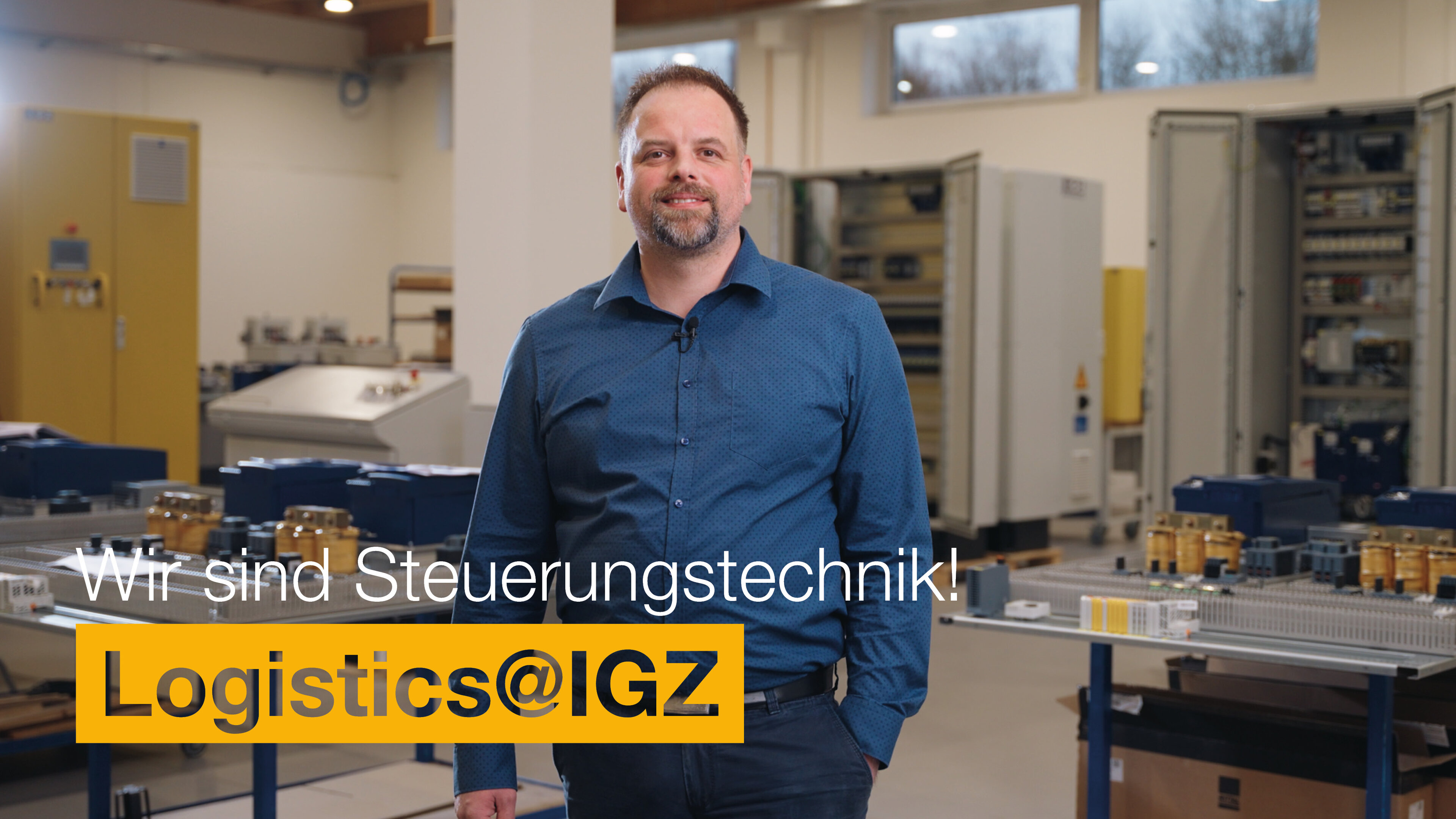 Mann mit Hemd und Hand in der Hosentasche steht in der Fabrik | Wir sind Steuerungstechnik | Logistics@IGZ: | IGZ