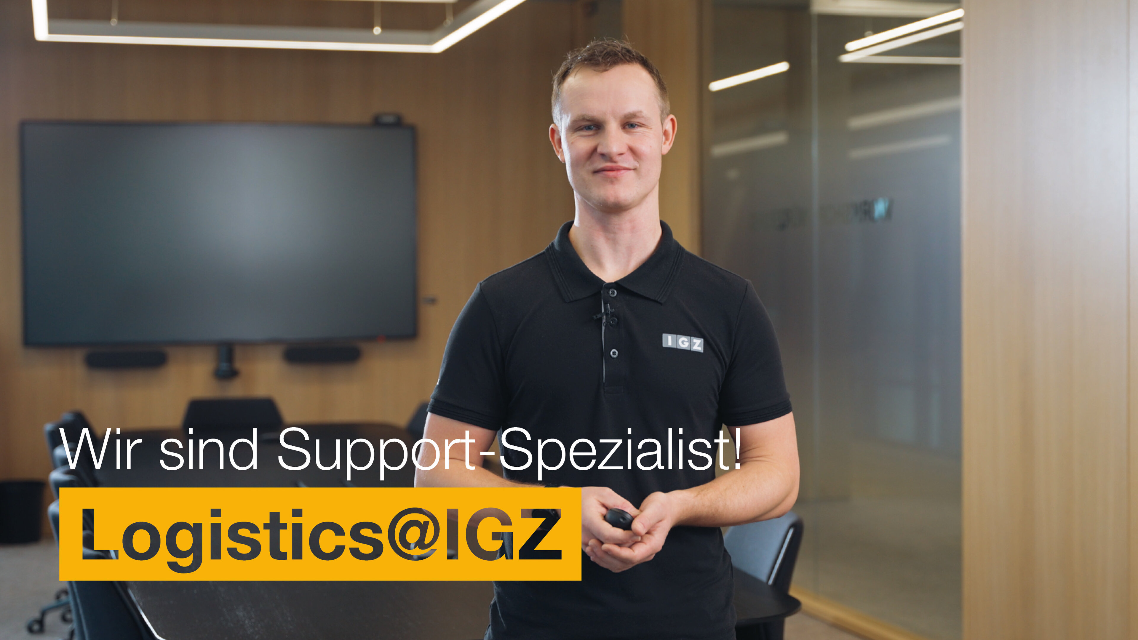 Mann mit Poloshirt steht im Besprechungsraum | Wir sind Support-Spezialist | Logistics@IGZ: | IGZ